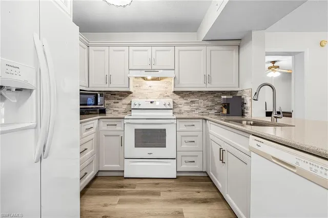 a kitchen with white cabinets and white appliances