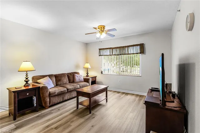 a living room with furniture and a dining table with wooden floor