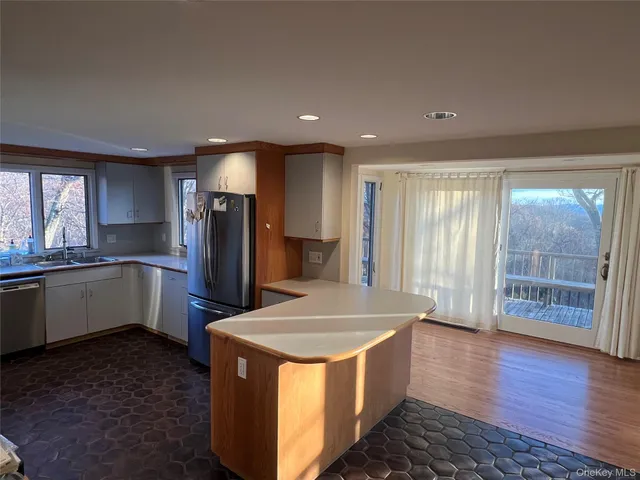 a kitchen with stainless steel appliances a refrigerator a sink a stove and cabinets