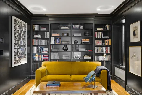 a living room with furniture and a book shelf