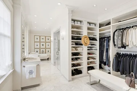 a view of walk in closet with clothes and shoes