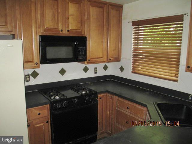 12704 Flack Street Silver Spring, MD 20906 - Photo 6 of 14 a kitchen with a stove and a microwave