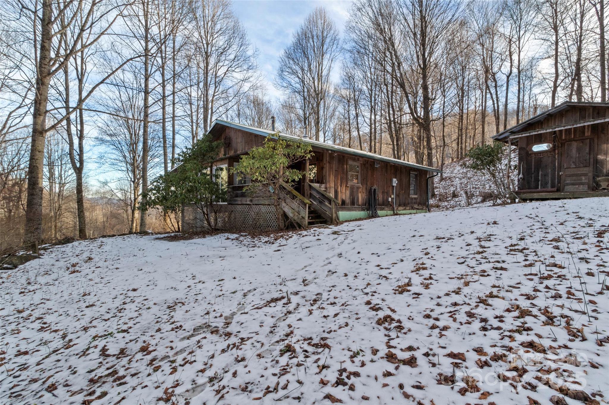1571 Roaring Fork Road Burnsville, NC 28714 - Photo 1 of 37 a view of a yard covered with snow in front of house