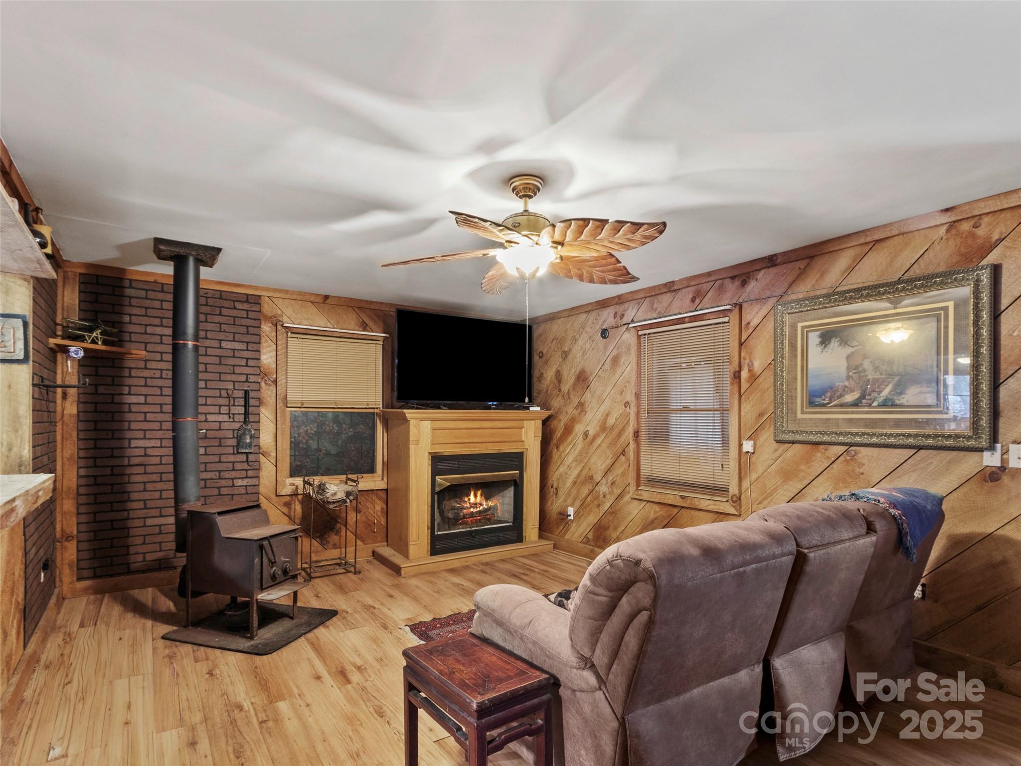 1571 Roaring Fork Road Burnsville, NC 28714 - Photo 22 of 37 a living room with furniture a flat screen tv and a fireplace