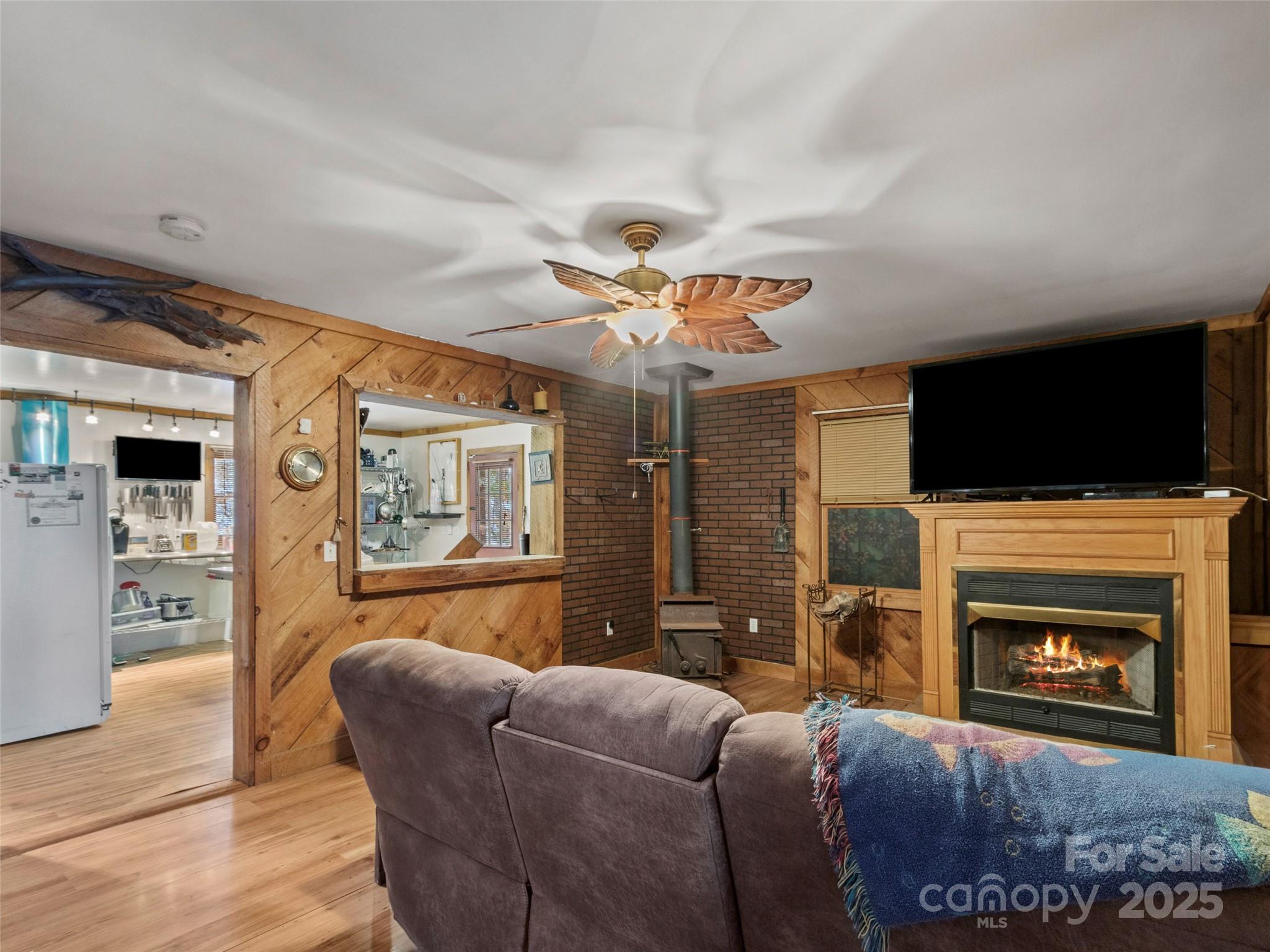 1571 Roaring Fork Road Burnsville, NC 28714 - Photo 23 of 37 a living room with furniture a flat screen tv and a fireplace