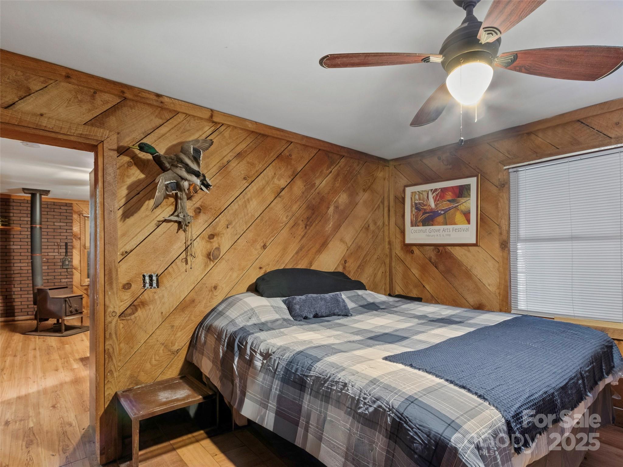 1571 Roaring Fork Road Burnsville, NC 28714 - Photo 29 of 37 a bedroom with a bed and a chandelier