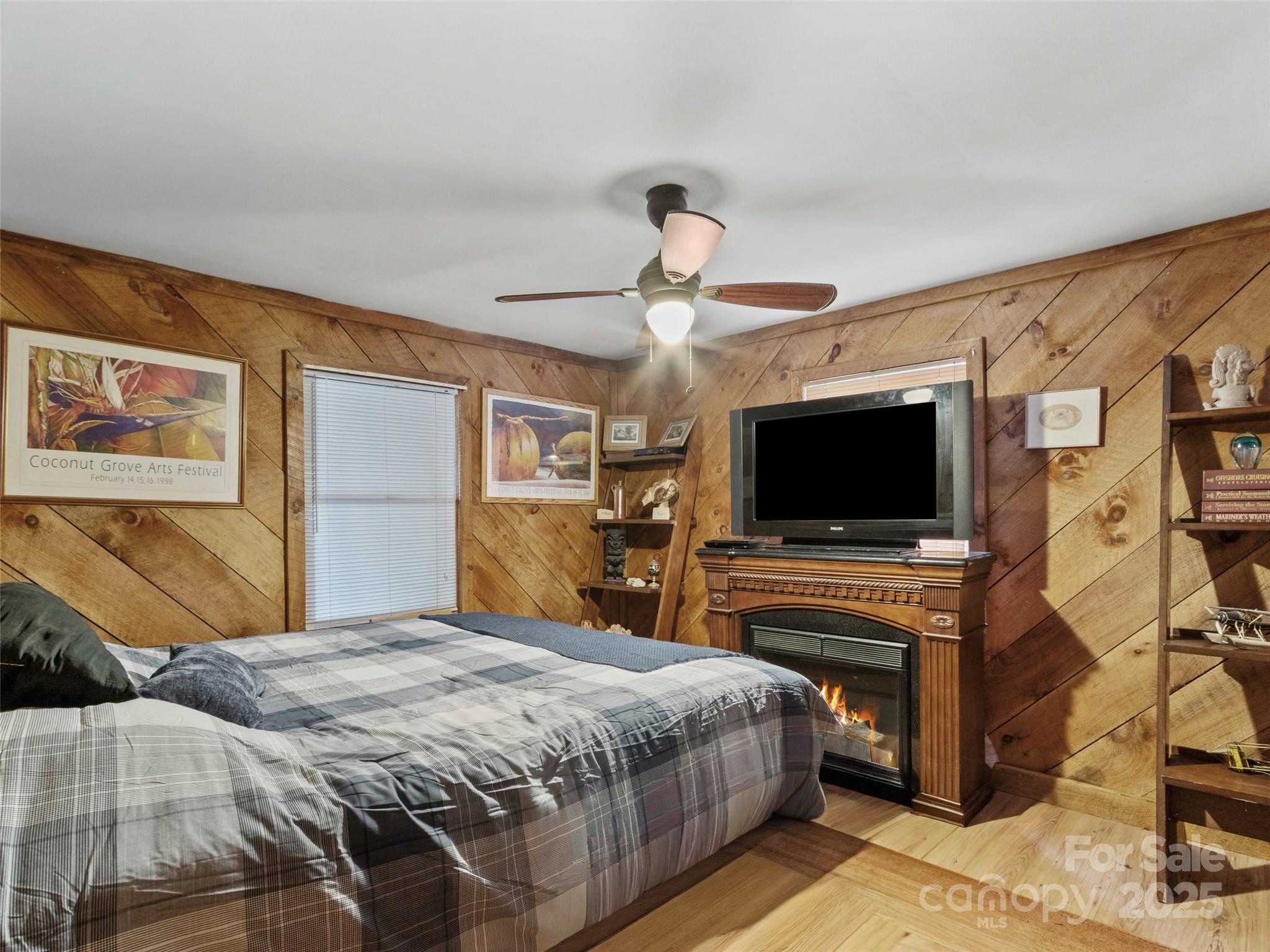 1571 Roaring Fork Road Burnsville, NC 28714 - Photo 30 of 37 a bedroom with a bed and a flat screen tv