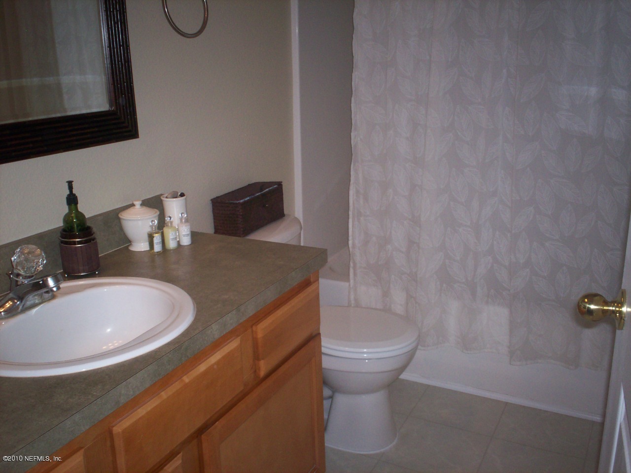 7920 Merrill Road, Unit 2104 Jacksonville, FL 32277 - Photo 7 of 9 a bathroom with a sink a toilet and a mirror