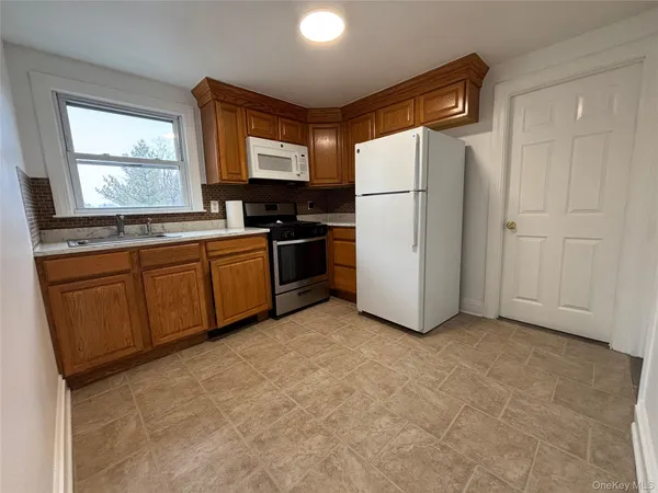 a kitchen with stainless steel appliances a refrigerator sink and microwave