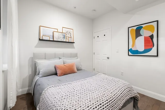 a bedroom with a bed and painting on the wall