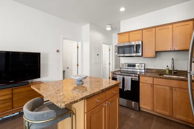 a kitchen with stainless steel appliances granite countertop a stove a sink and a microwave