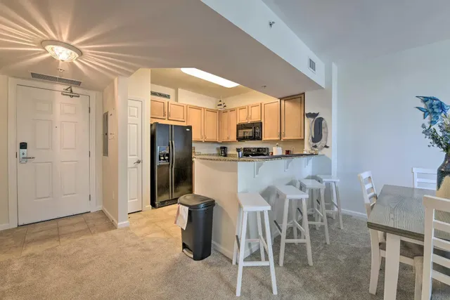a kitchen with stainless steel appliances kitchen island granite countertop a refrigerator and microwave