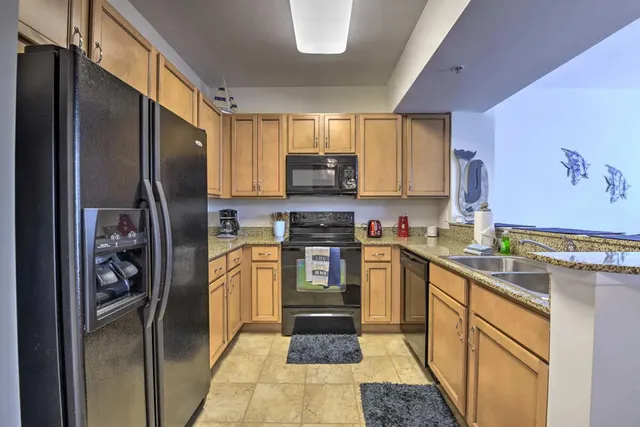 a kitchen with stainless steel appliances granite countertop a refrigerator stove and sink