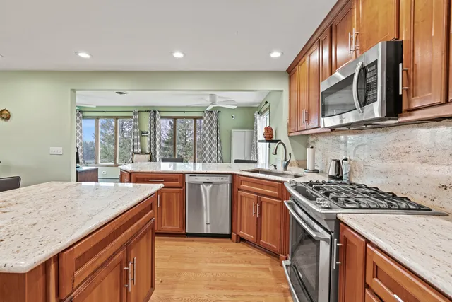 a kitchen with stainless steel appliances granite countertop a sink stove and cabinets