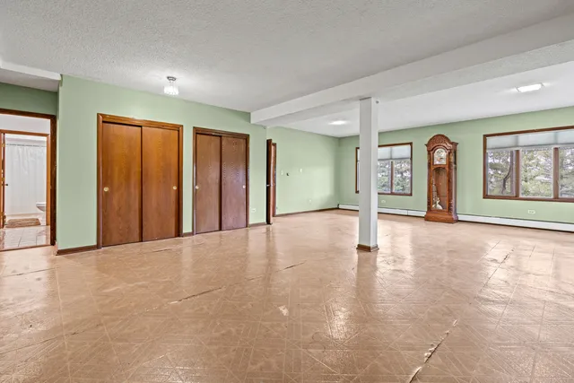 an empty room with windows and closet