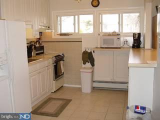 67 Granite Road Levittown, PA 19057 - Photo 3 of 6 a kitchen with a refrigerator and white cabinets