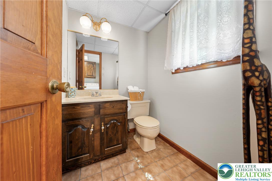 947 Tamenend Road Bath, PA 18014 - Photo 8 of 61 Well-lit bathroom with a wooden vanity and practical tiled flooring.