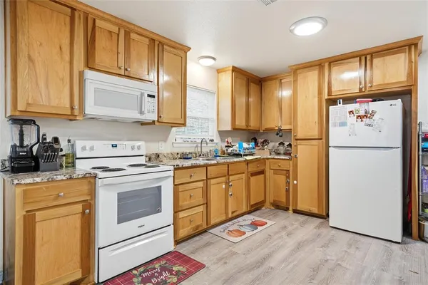 a kitchen with stainless steel appliances granite countertop a refrigerator sink and cabinets