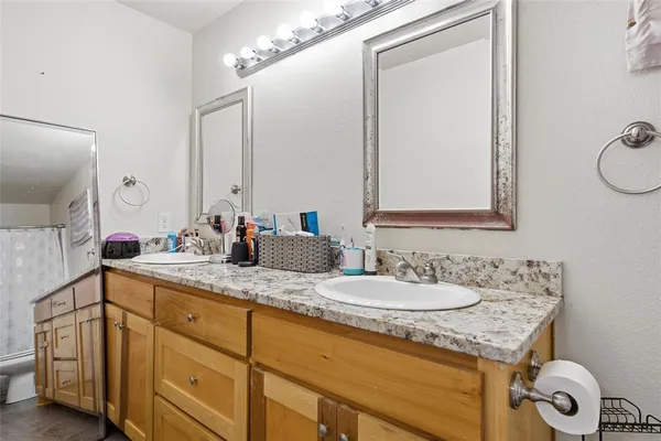 a bathroom with a granite countertop sink and a mirror