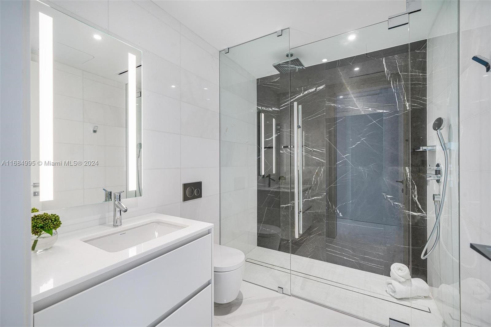 300 Biscayne Blvd Way, Unit 701 Miami, FL 33131 - Photo 22 of 37 a bathroom with a shower sink and mirror