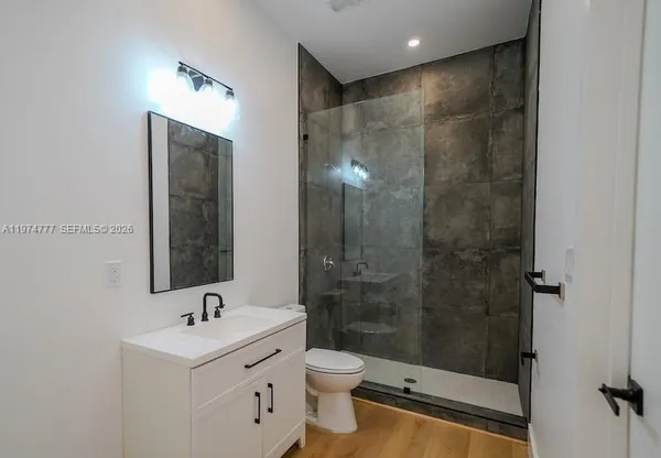 a bathroom with a shower toilet sink and mirror