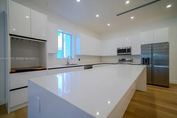 a large kitchen with stainless steel appliances a refrigerator and a stove top oven
