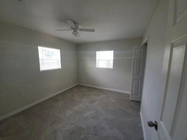 an empty room with windows and closet