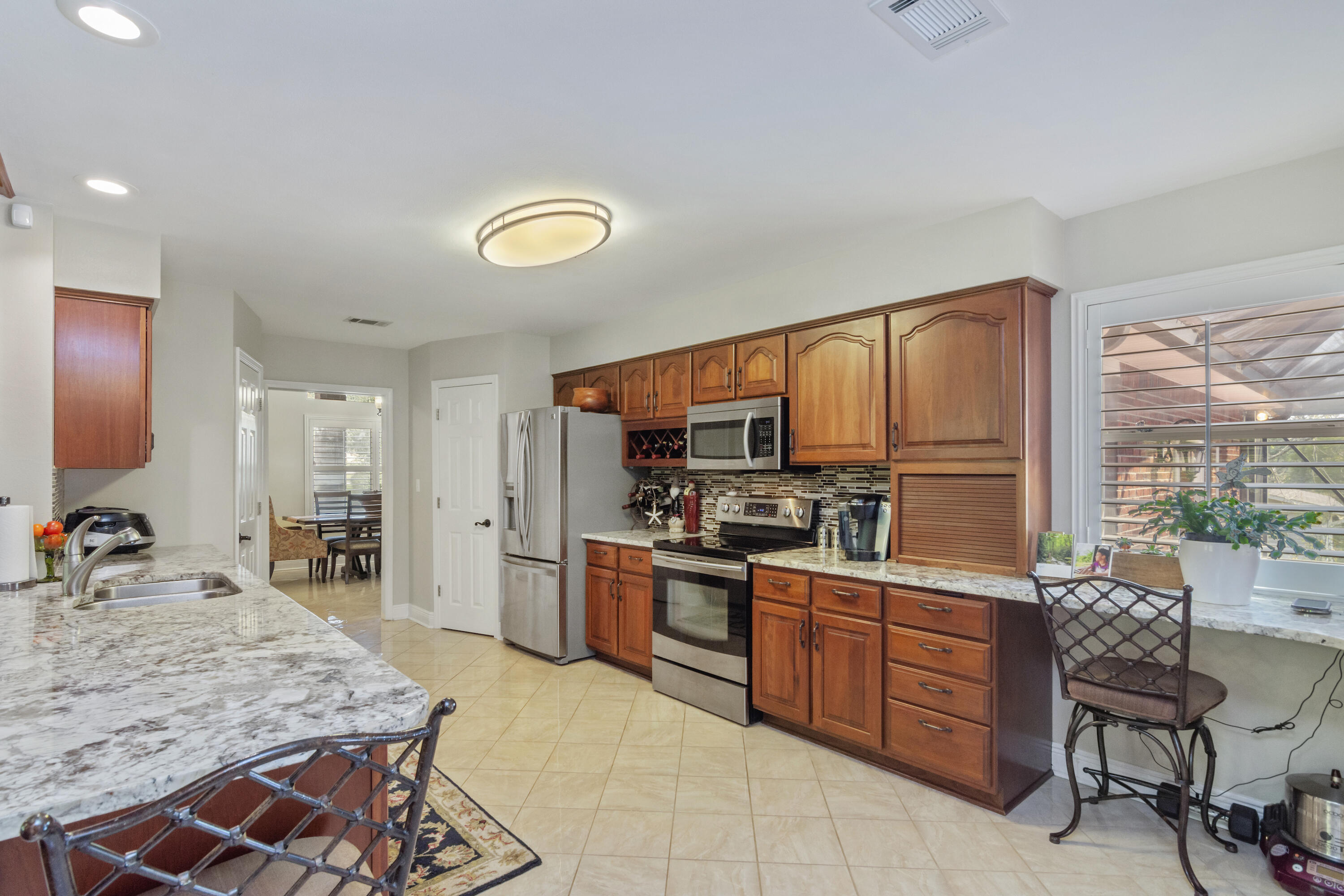 5766 Wildwood Road Crestview, FL 32536 - Photo 7 of 45 a kitchen with a stove a sink and a refrigerator