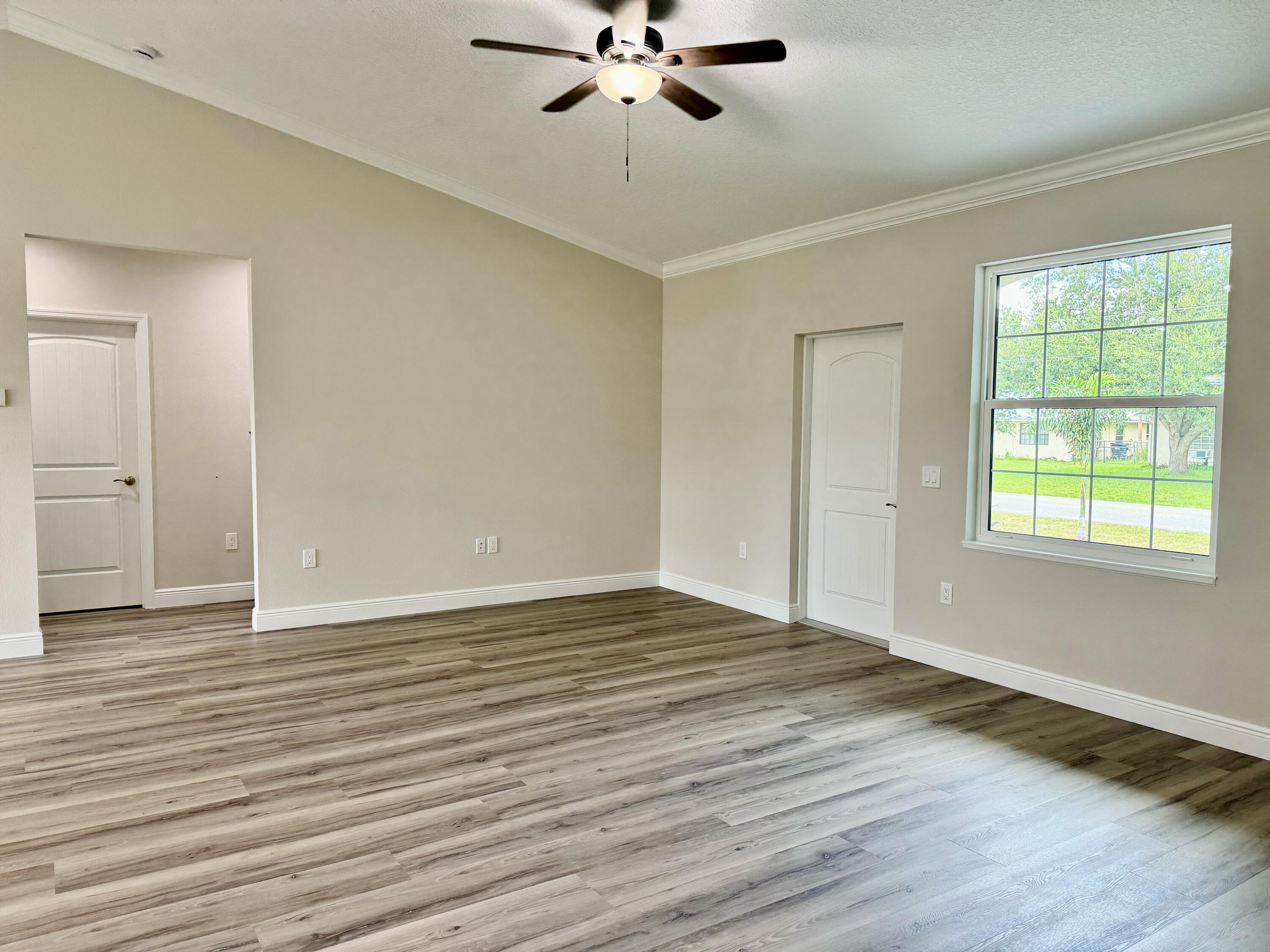 553 Southeast 36th Terrace Okeechobee, FL 34974 - Photo 3 of 21 a view of an empty room with wooden floor and a window
