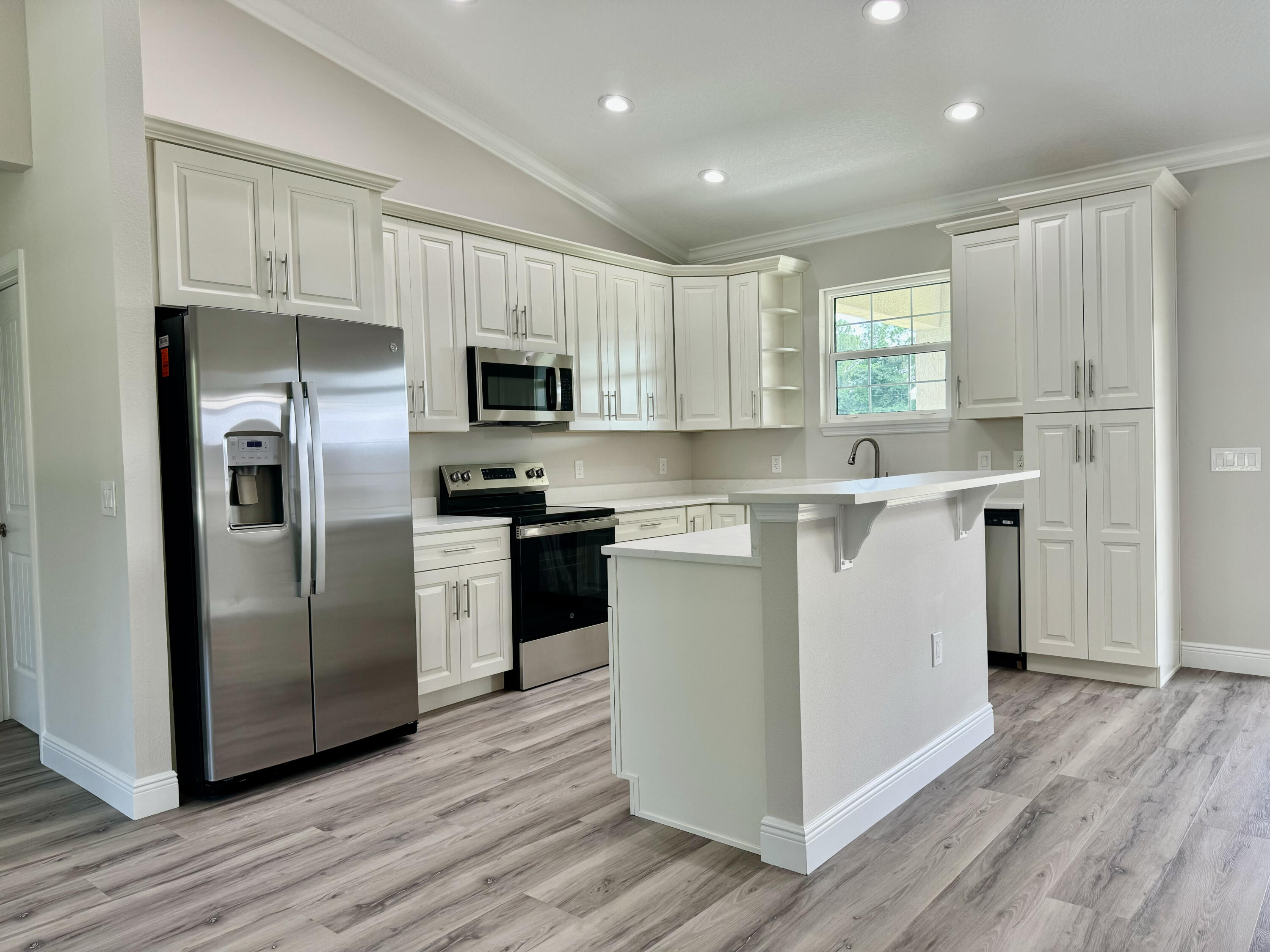 553 Southeast 36th Terrace Okeechobee, FL 34974 - Photo 4 of 21 a kitchen with kitchen island a refrigerator sink and cabinets