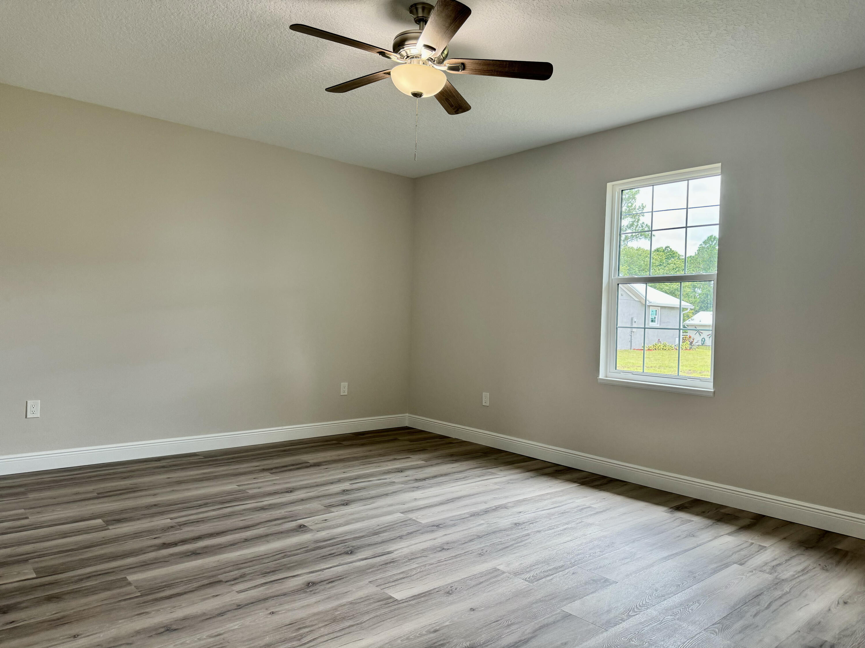 553 Southeast 36th Terrace Okeechobee, FL 34974 - Photo 8 of 21 a view of empty room with wooden floor and fan