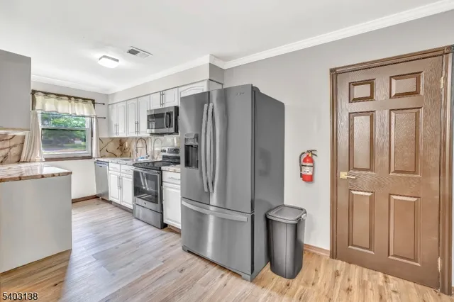 a kitchen with a refrigerator sink and wooden floor