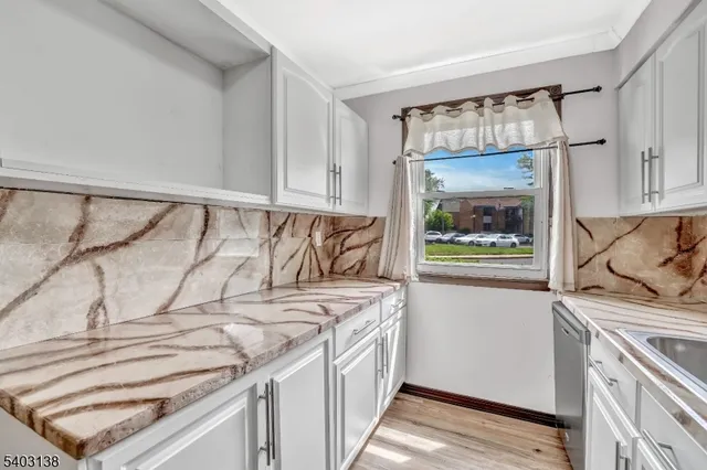 a view of a kitchen with a sink and wooden floor
