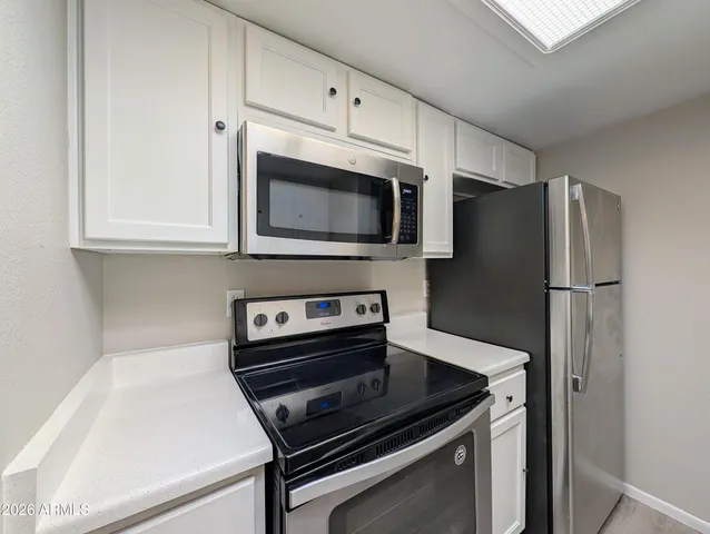 a kitchen with appliances a sink and cabinets