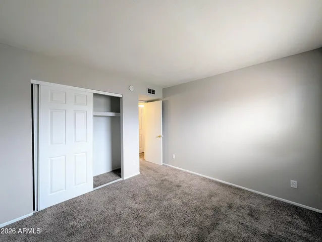an empty room with closet and a bathroom