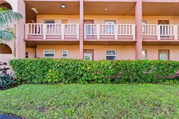 a front view of a multi story residential apartment building with a yard