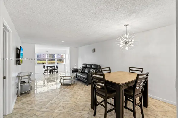 a view of a dining room with furniture and a chandelier