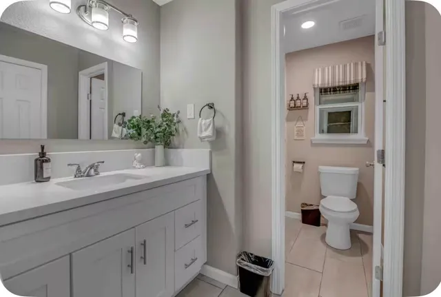 a bathroom with a toilet sink and mirror