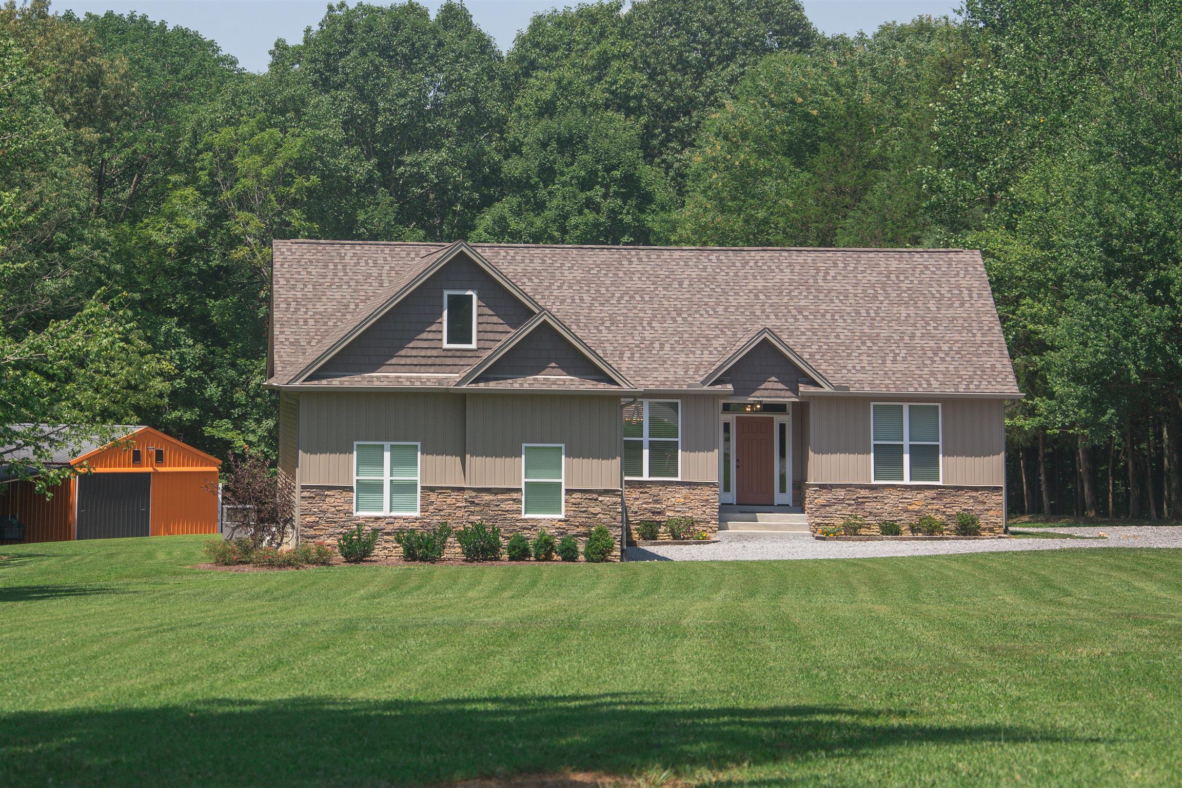 1045 North Corinth Road Portland, TN 37148 - Photo 3 of 29 a front view of a house with a garden and trees