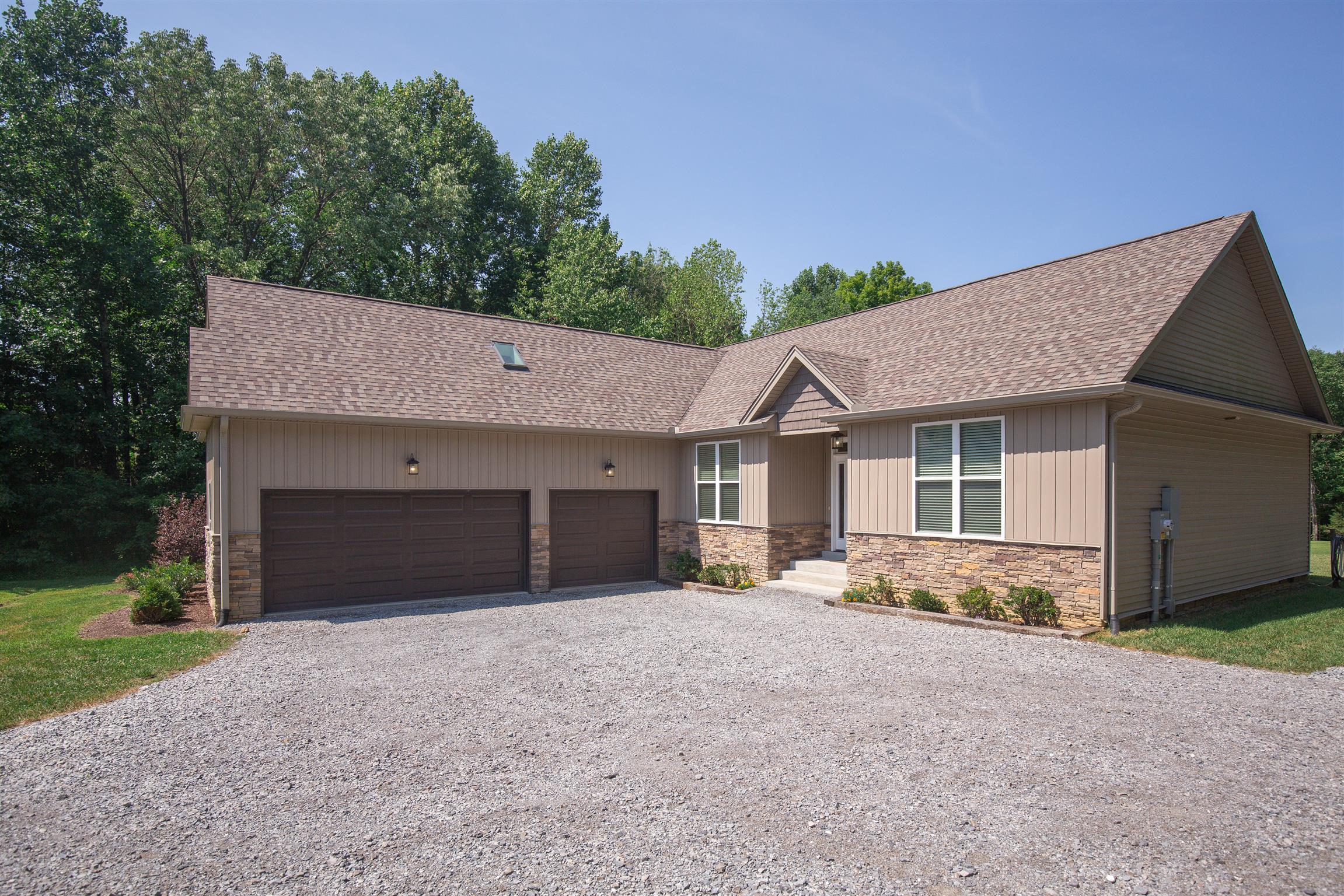 1045 North Corinth Road Portland, TN 37148 - Photo 5 of 29 a front view of a house with a yard and garage