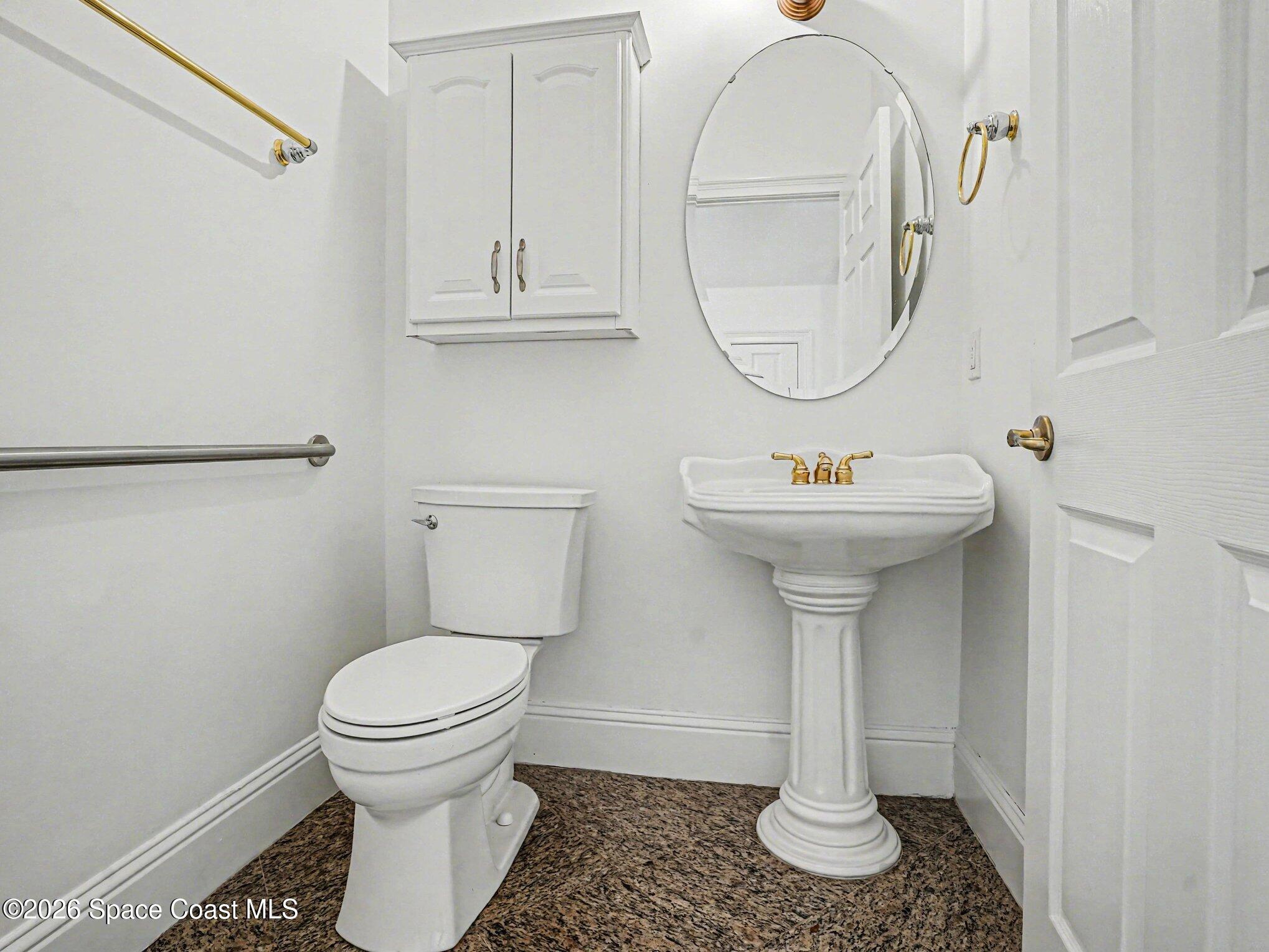 11940 Kirby Smith Road Orlando, FL 32832 - Photo 22 of 39 a bathroom with a sink toilet and a mirror
