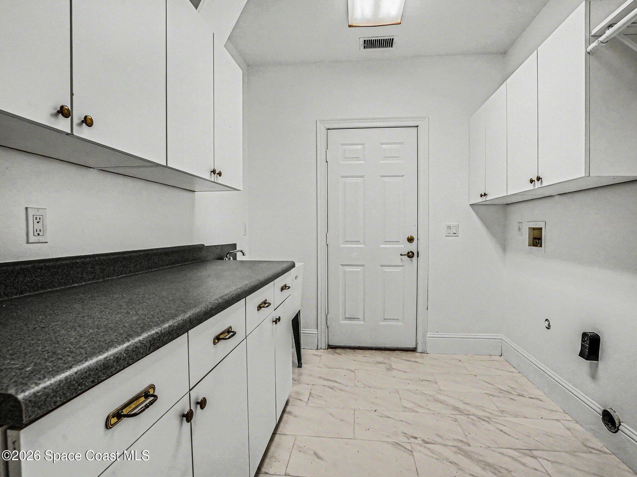 11940 Kirby Smith Road Orlando, FL 32832 - Photo 24 of 39 a kitchen with white cabinets and a stove