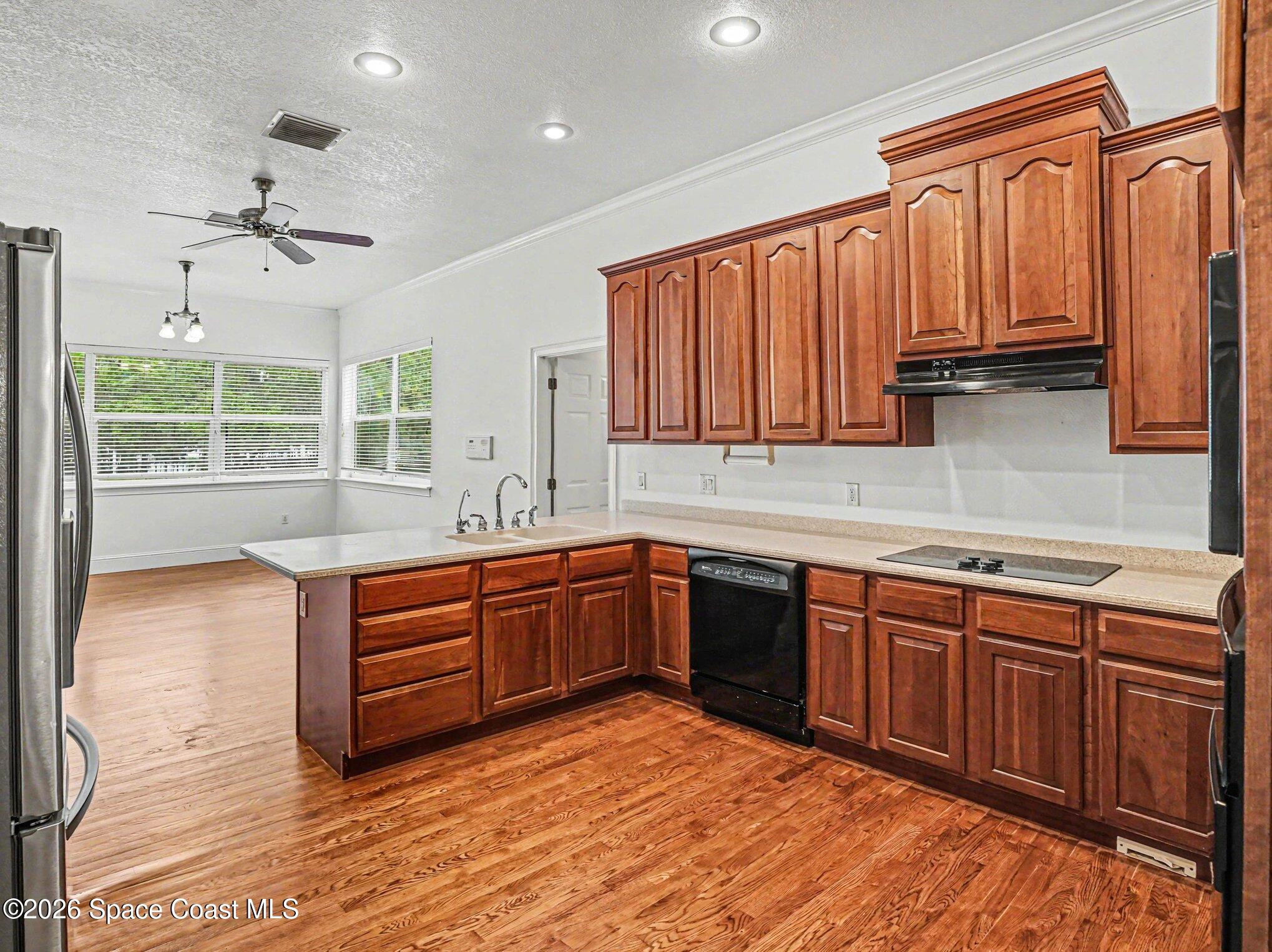 11940 Kirby Smith Road Orlando, FL 32832 - Photo 3 of 39 a kitchen with stainless steel appliances granite countertop a stove a sink dishwasher and a microwave oven with cabinets