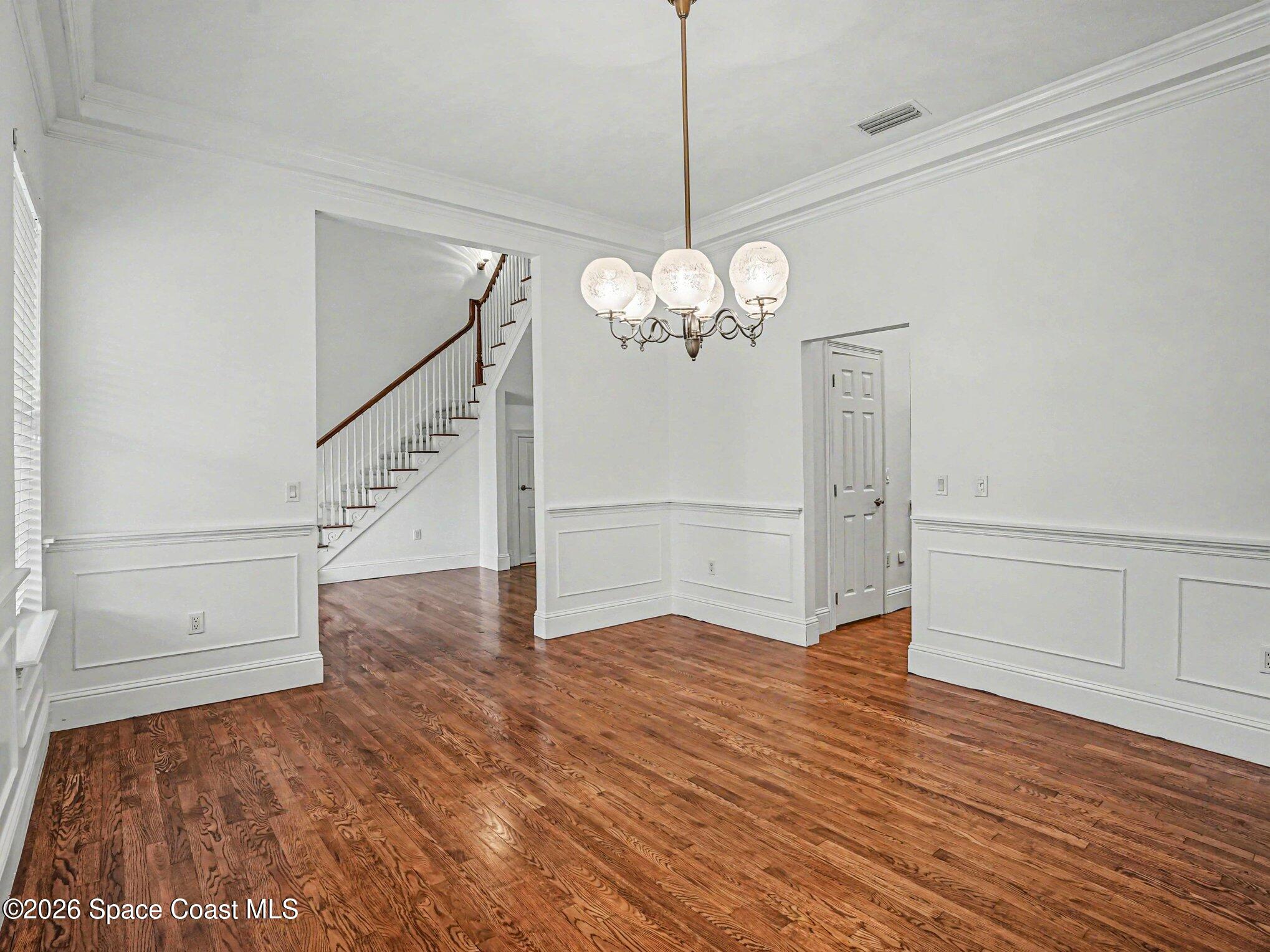 11940 Kirby Smith Road Orlando, FL 32832 - Photo 6 of 39 a view of an empty room with wooden floor and staircase