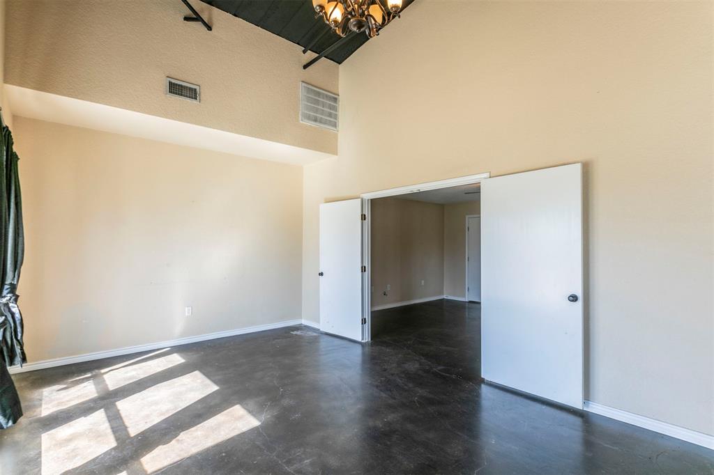 32471 Highway 108 Mingus, TX 76463 - Photo 11 of 40 Unfurnished room featuring finished concrete flooring, visible vents, a towering ceiling, an inviting chandelier, and baseboards