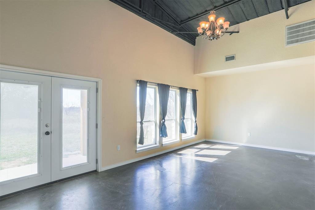 32471 Highway 108 Mingus, TX 76463 - Photo 9 of 40 Empty room featuring french doors, visible vents, finished concrete floors, a chandelier, and baseboards