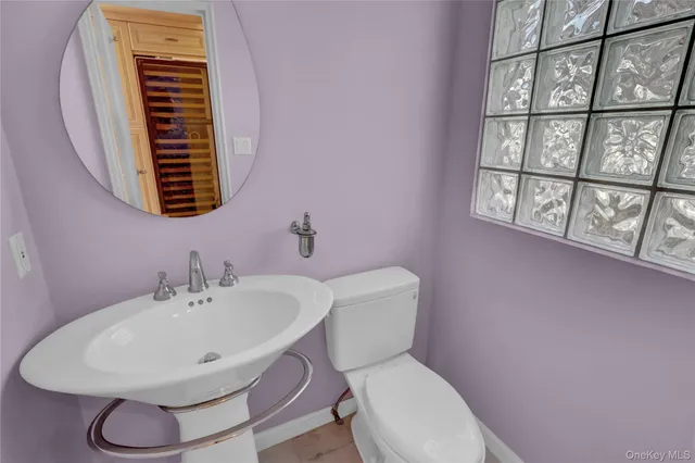 a bathroom with a sink a toilet and a mirror