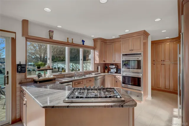a kitchen with stainless steel appliances granite countertop a stove a sink and a refrigerator