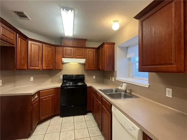 a kitchen with a sink stove and cabinets