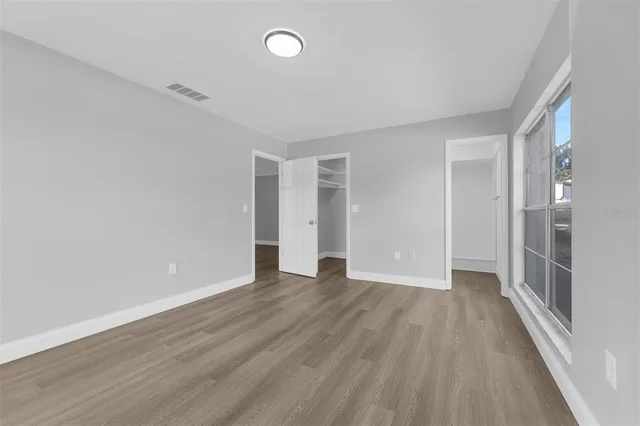 a view of an empty room with wooden floor